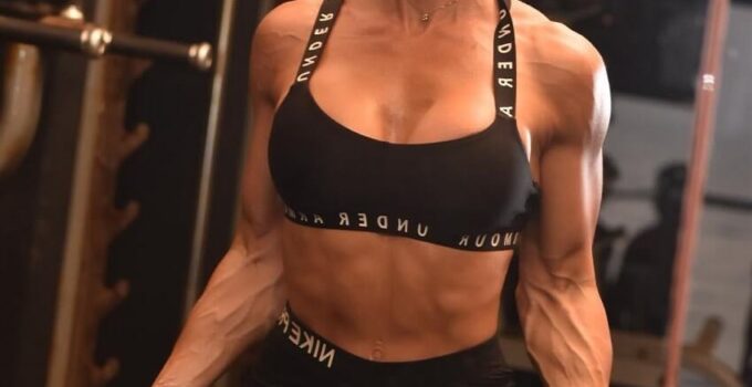 Danni Levy doing biceps curls in the gym