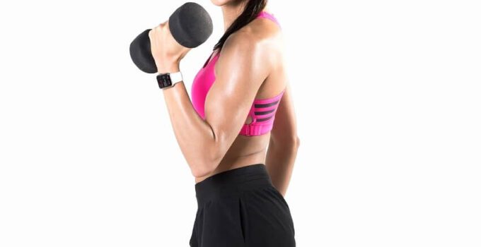Kayla Itsines posing with a dumbbell in a fitness photo shoot