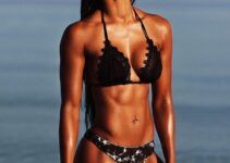 Melissa Carver smiling and posing in a bikini on the beach, looking fit and awesome
