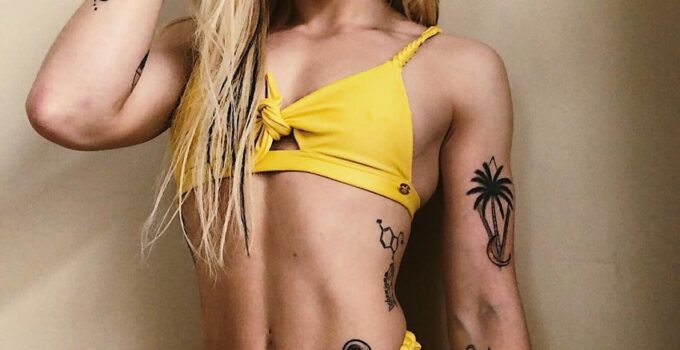 Skylar Stegner posing in a yellow bikini looking lean and fit