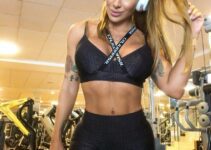 Jaque Khury posing in a gym with headphones looking fit and healthy