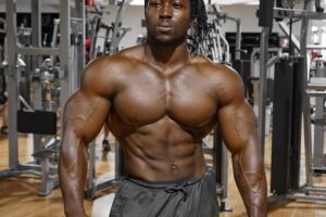 Kwame Duah posing shirtless in the gym