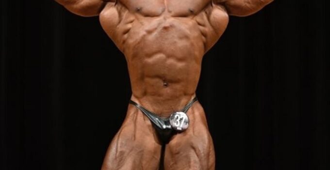 Ahmed Elsadany flexing front double biceps on a bodybuilding stage