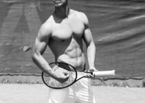 Edoardo Santonocito standing shirtless on a tennis court with a tennis racket in his hand