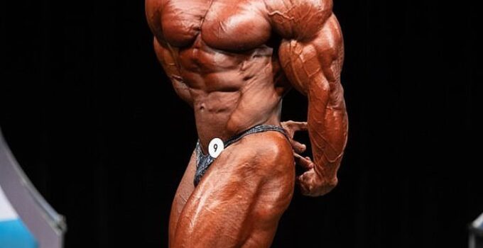 Alexis Rivera Rolon doing a side triceps pose on a bodybuilding stage, looking confident and impressive