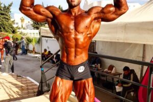 Ahmad Parvin doing a front double biceps pose looking strong