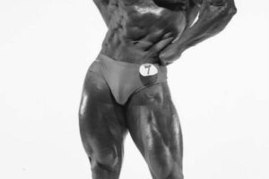 Albert Beckles flexing his biceps shirtless bodybuilding