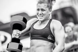 Alexis Johnson lifting a heavy dumbbell during a CrossFit competition