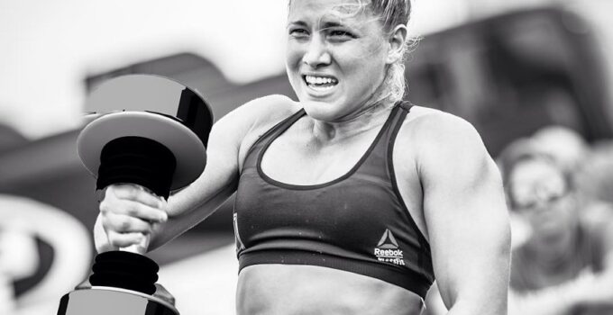 Alexis Johnson lifting a heavy dumbbell during a CrossFit competition