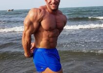 Ayat Bagheri doing a side triceps pose on the beach