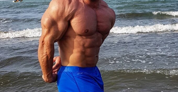 Ayat Bagheri doing a side triceps pose on the beach