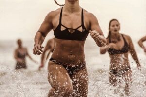 Dani Elle Speegle running in shallow water competing against other athletes