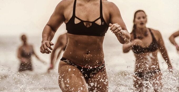 Dani Elle Speegle running in shallow water competing against other athletes