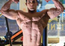 Ernane Guimaraes flexing shirtless front double biceps