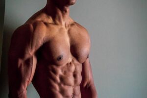 Evan Johnson posing shirtless looking ripped