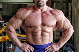 Fernando Sardinha posing shirtless in the gym, looking huge and ripped