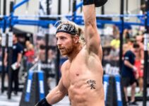 Graham Holmberg lifting a kettlebell over his head during a CrossFit competition