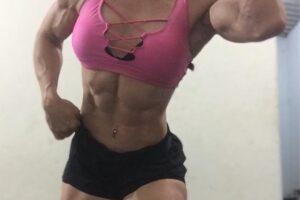 Kelly Karina flexing for the photo looking ripped and toned