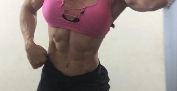 Kelly Karina flexing for the photo looking ripped and toned