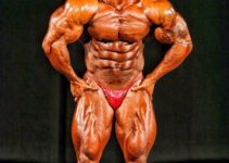 Kris Dim flexing most muscular on a bodybuilding stage