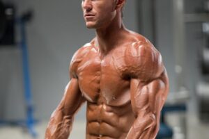 Mark Robinson posing shirtless with dumbbells