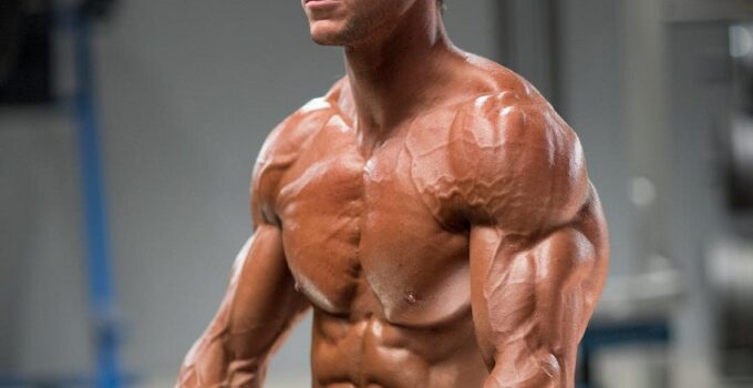 Mark Robinson posing shirtless with dumbbells