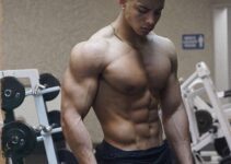 Michael Smith posing shirtless in the gym looking fit and lean