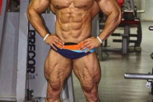 Mohammed Foda posing shirtless in the gym, looking massive and ripped