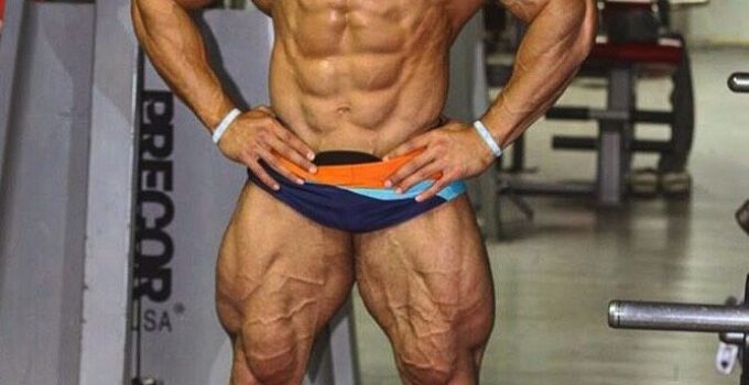 Mohammed Foda posing shirtless in the gym, looking massive and ripped