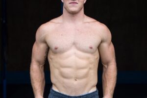 Noah Ohlsen posing shirtless for a photo looking fit and strong