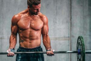 Rasmus Wisbech Andersen shirtless, doing heavy barbell biceps curls