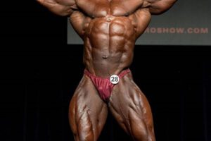 Ricardo Correia hitting a front double biceps pose on the bodybuilding stage