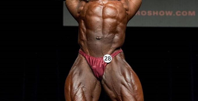 Ricardo Correia hitting a front double biceps pose on the bodybuilding stage