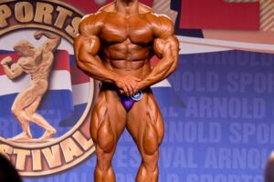 Samir Troudi flexing in his most muscular pose on the bodybuilding stage