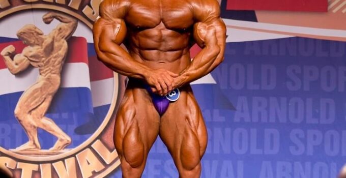 Samir Troudi flexing in his most muscular pose on the bodybuilding stage