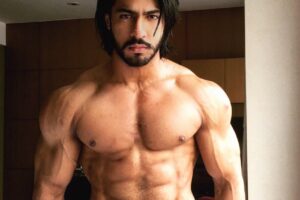 Thakur Anoop Singh posing shirtless with a towel around his belt looking strong and ripped