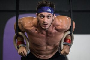 Travis Williams performing CrossFit ring dips, looking ripped and fit