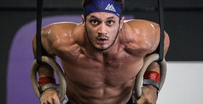 Travis Williams performing CrossFit ring dips, looking ripped and fit