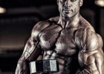 Henri-Pierre Ano lifting a dumbbell while looking at the camera, looking ripped and lean