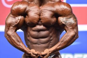 Abdelaziz Jellali flexing his muscles in a bodybuilding contest in front of an audience