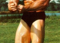 Bob Gajda in a most muscular pose outdoors, standing on the grass, and posing for a photo