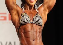 Chloe Sannito flexing her abs on a bodybuilding stage