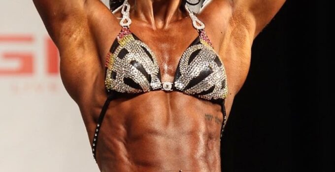 Chloe Sannito flexing her abs on a bodybuilding stage