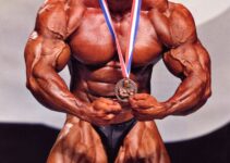 Dennis Wolf flexing on the stage with a medal around his neck