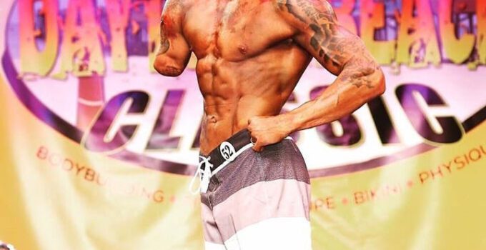 Jared Bullock on stage at a bodybuilding competition.,