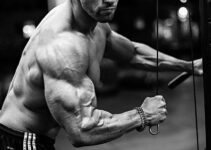 Julian Smith training shirtless with cables in a gym looking ripped