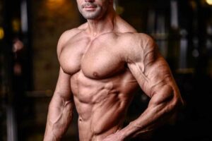 Mohammad Kashanaki posing for the picture, showing his ripped arms and shoulder, chest, abs, and obliques