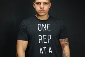 ObesetoBeast posing for a photo in a black shirt with motivational quote "One Rep at a time"