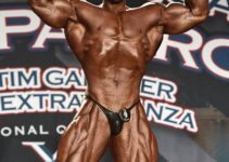 Regan Grimes flexing front double biceps on the boybuilding stage