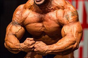 Sergio Oliva Jr in a most muscular pose on the stage